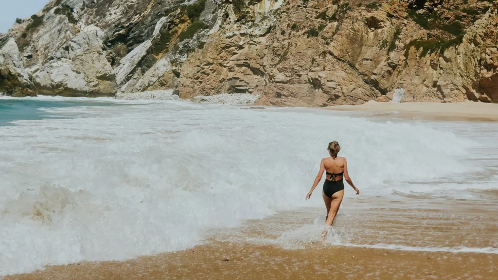 Mulher caminhando em direção às ondas do mar